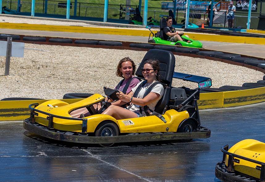 Two girls riding together in a go cart at Jolly Roger Amusement Park in Ocean City, MD